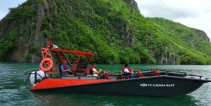 Boarding the Safari boat on Koman Lake surrounded by cliffs and greenery