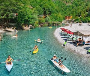 Tourists canoeing on Shala River in North Albania surrounded by stunning natural scenery