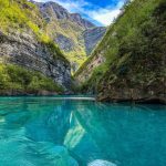 Portrait view of Koman Lake surrounded by majestic mountains in Albania.