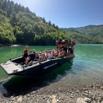 Tourists smiling and enjoying a scenic boat ride on Komani Lake with North Albania Boat.