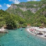 Shala River shoreline with umbrellas and seating, perfect for relaxation and enjoying the scenic views.