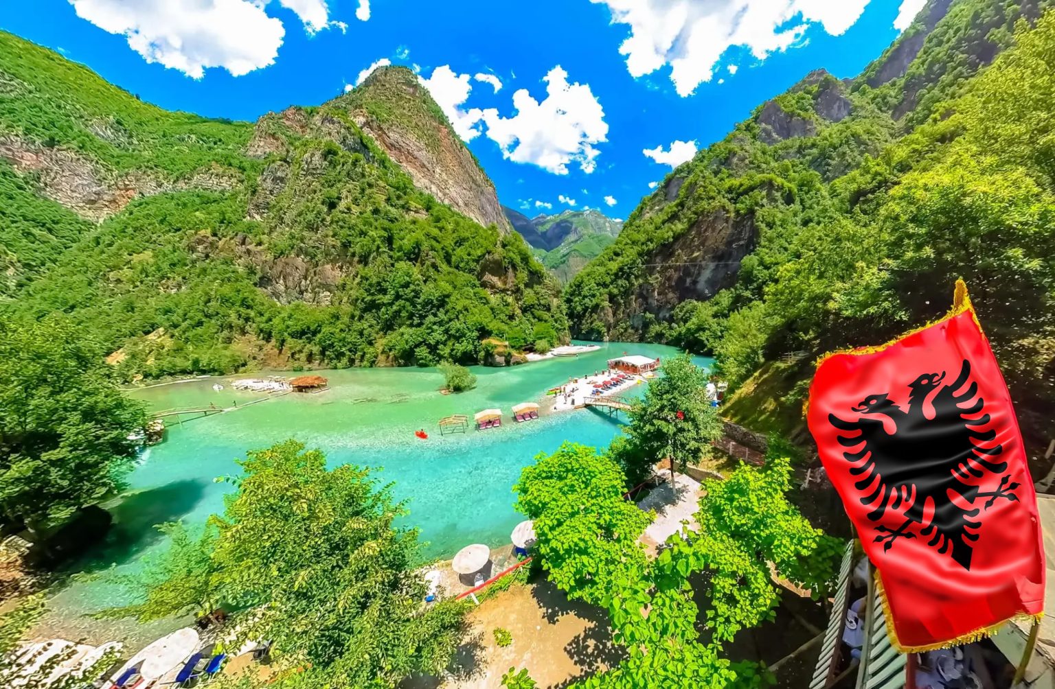 Shala River with crystal blue waters, surrounded by mountains and a blue sky with white clouds