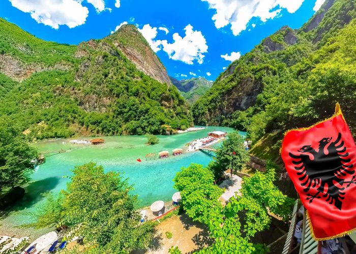 Shala River with crystal blue waters, surrounded by mountains and a blue sky with white clouds