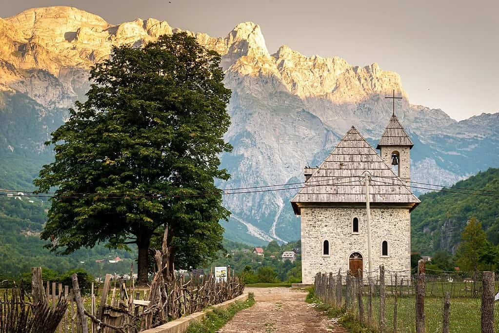 Theth church Albania traditional stone building limestone mountain peaks sunrise Albanian Alps northern Albania