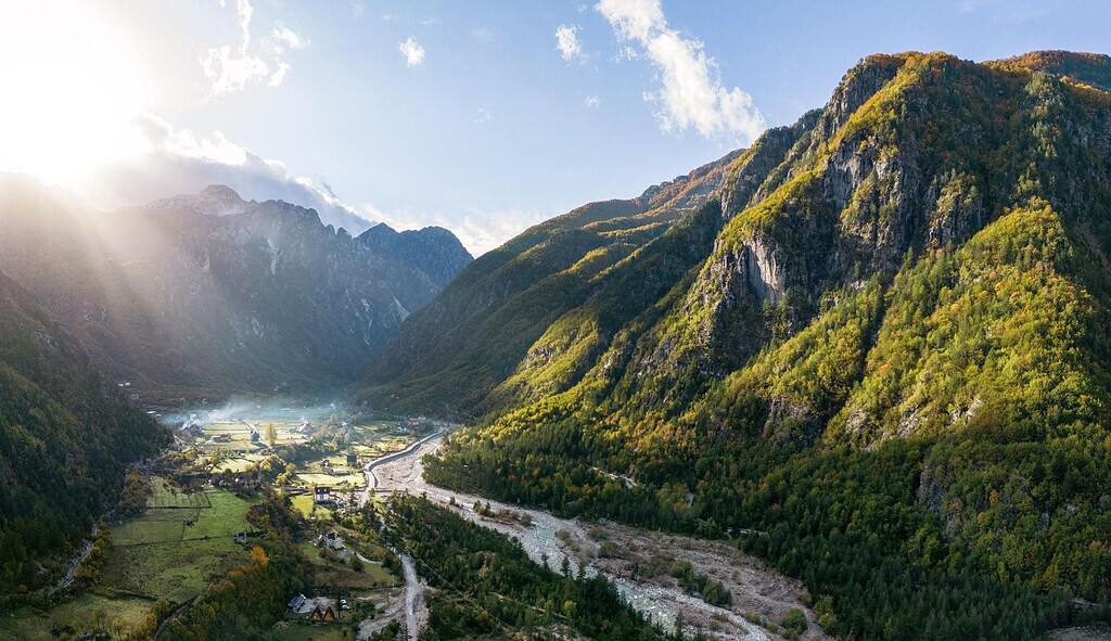 Theth valley Albania aerial sunset view village river meadows limestone mountains Albanian Alps