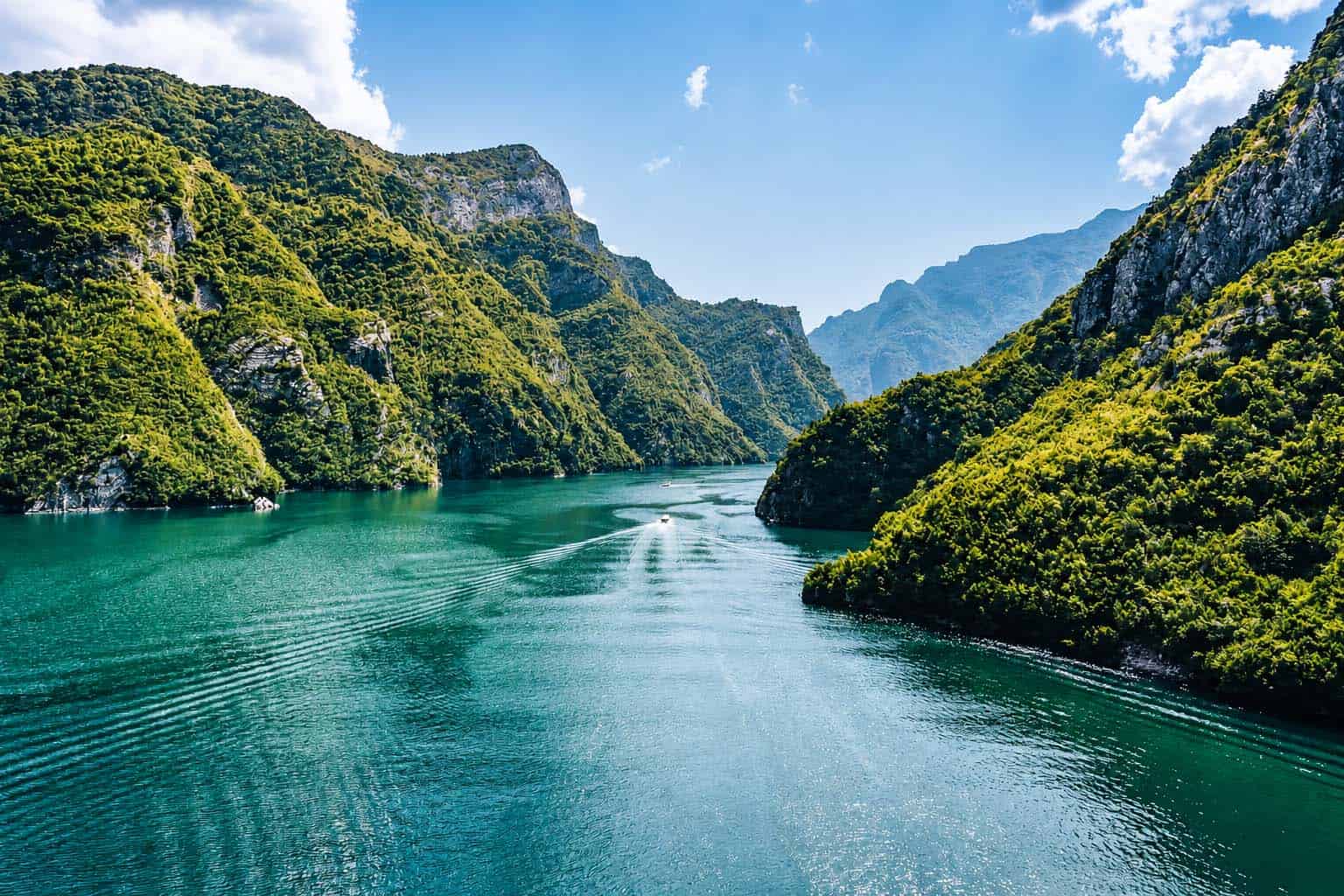 Komani Lake Albania fjord-like canyon with turquoise water lush greenery and mountain cliffs