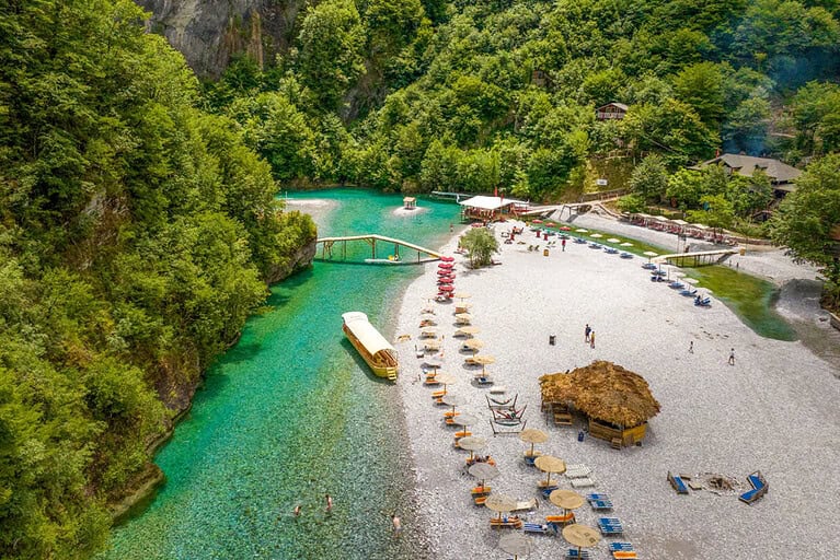 Shala River beach with turquoise water and mountain landscape during a daily boat tour from Lezhe in northern Albania
