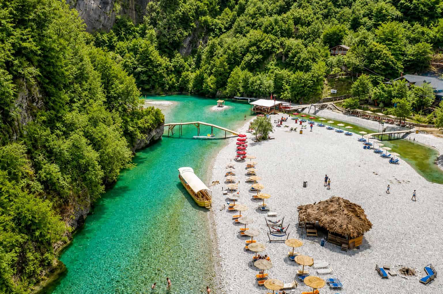 Shala-flodens strand med turkisblåt vand og bjerglandskab under en daglig bådtur fra Lezhë i det nordlige Albanien