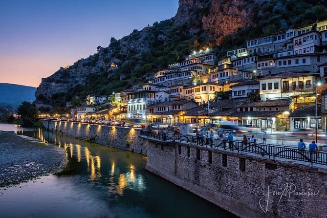 Berat old town houses lit up at dusk above the river, Albania