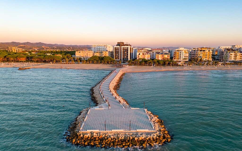 Aerial sunset view of Durres beach promenade and breakwater on the Adriatic coast, Albania