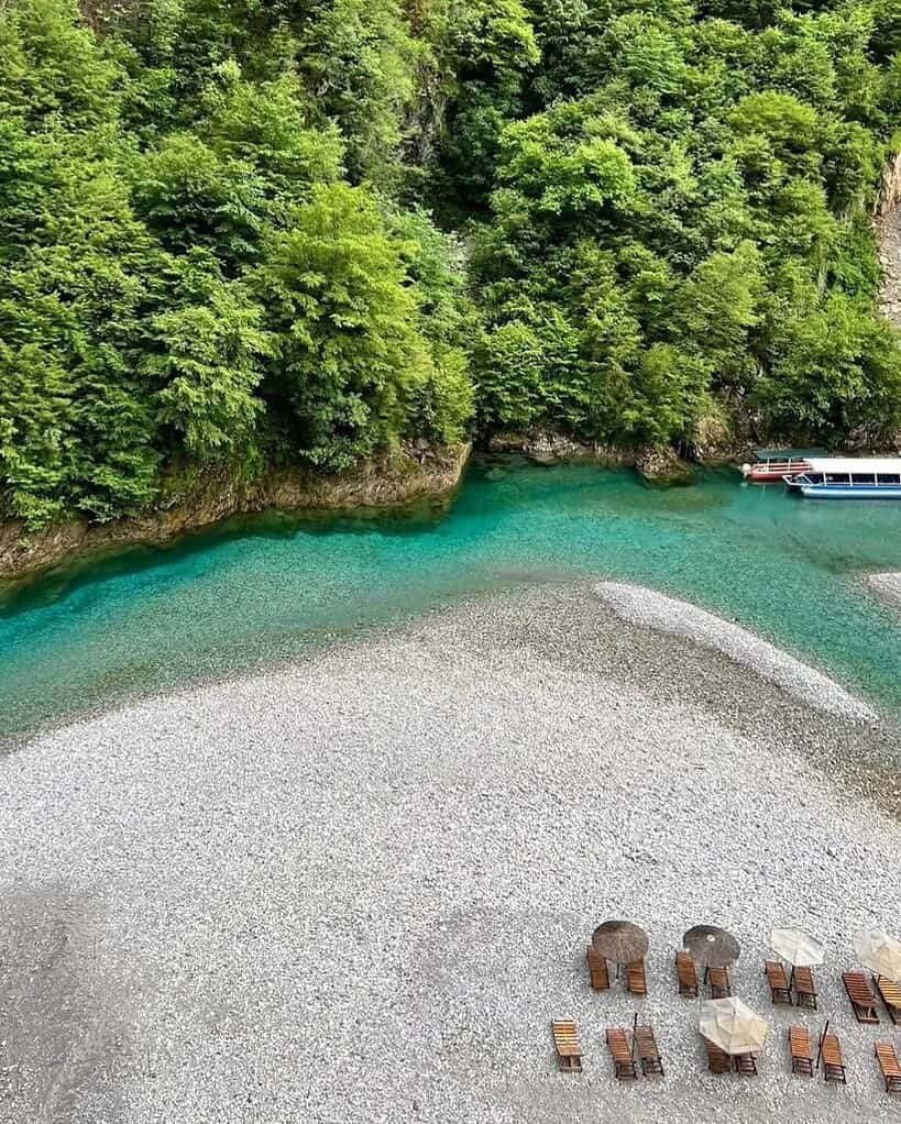 Aerial view of turquoise cove and sun loungers on Shala River