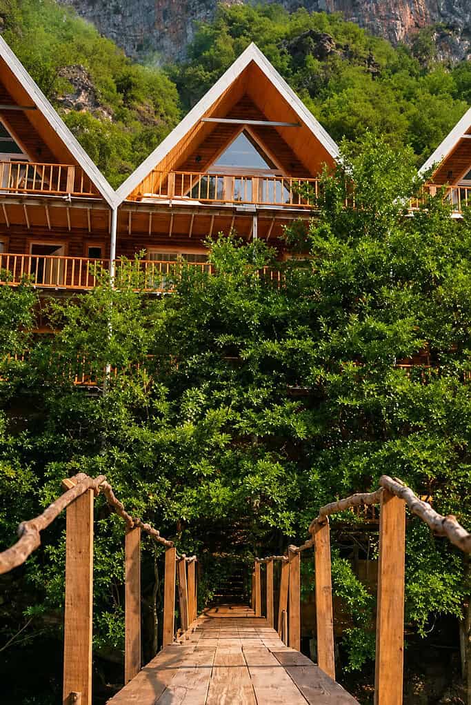 Wooden A-frame guesthouses above Shala River reached by a rope bridge, Albania