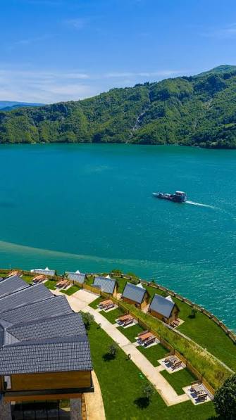 Lakeside cabins overlooking the turquoise waters of Komani Lake in Albania