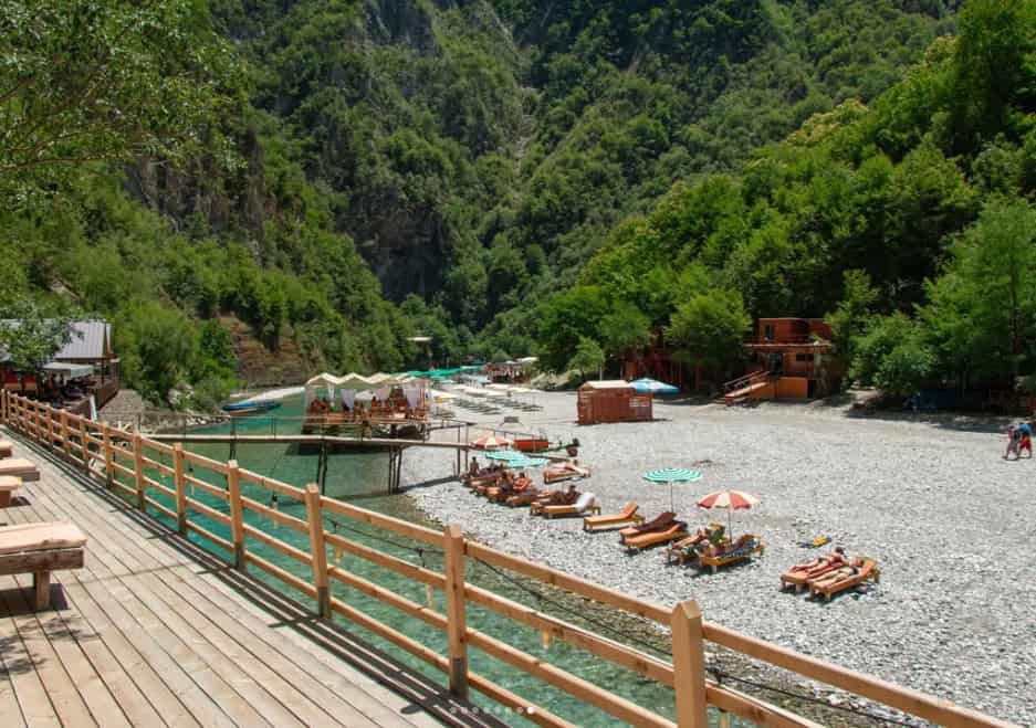 Wooden boardwalk overlooking the beach and cabins at Shala River, Albania