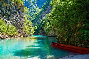 Turquoise waters of Shala River surrounded by steep green canyon walls in northern Albania