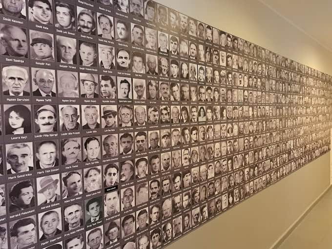 Museum wall covered in black-and-white portraits of people persecuted under Albania's communist regime